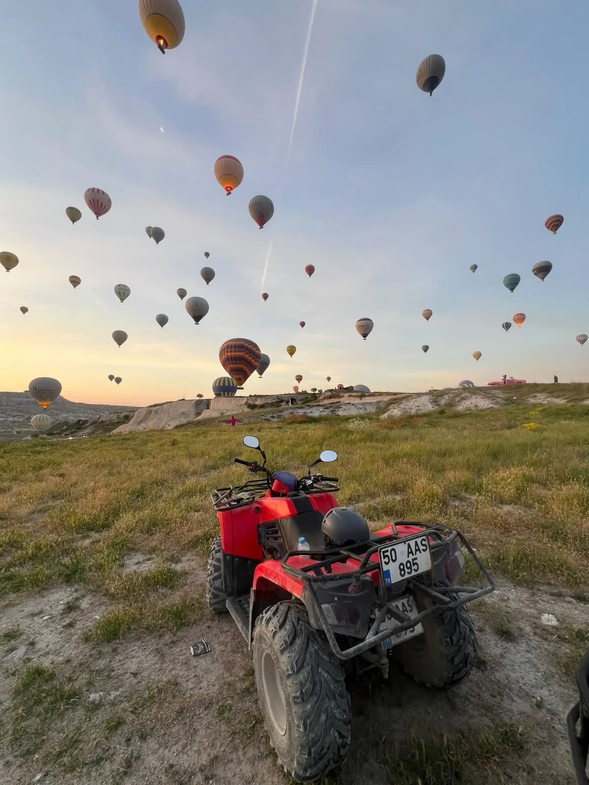 Gün doğumunda Göreme semasındaki balonlar ve kırmızı ATV